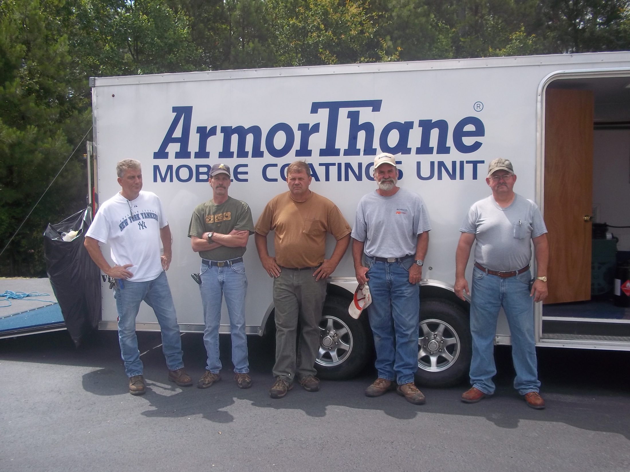 A training class lined up in front of the ArmorThane Mobile Coatings Unit