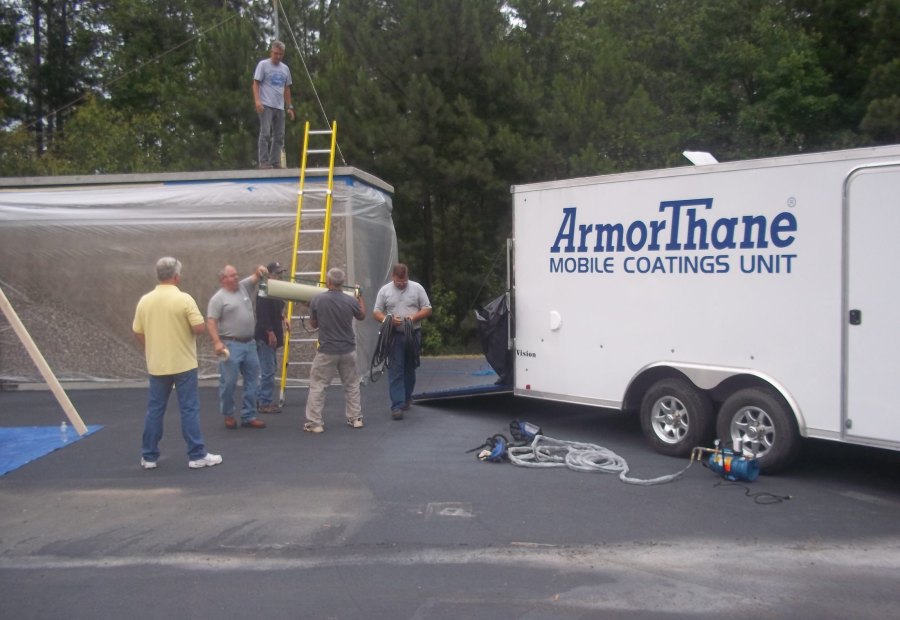 A class gathered around a temporary spray enclosure beside the ArmorThane Mobile Coatings Unit