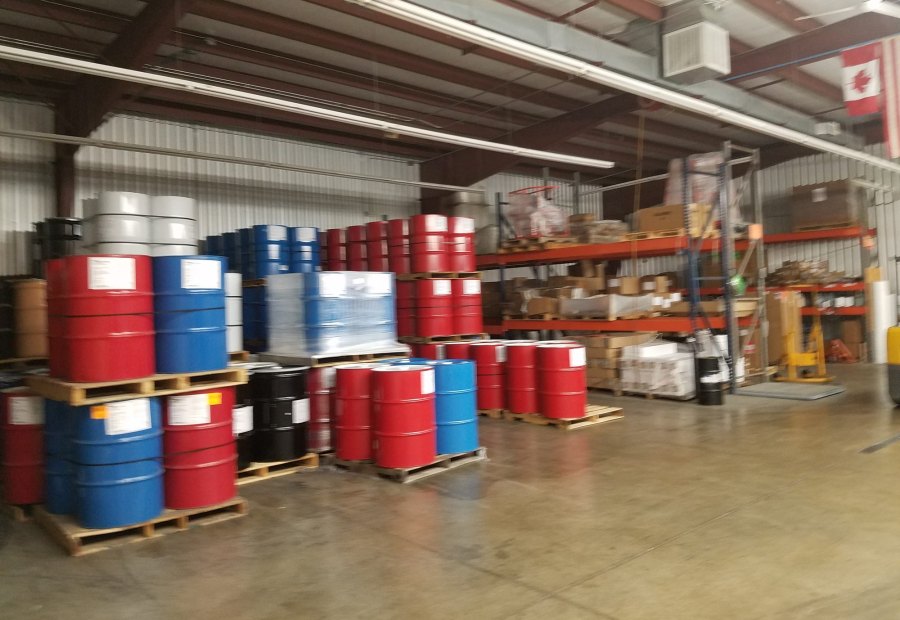 Pallets of coating material drums stacked in a distribution warehouse